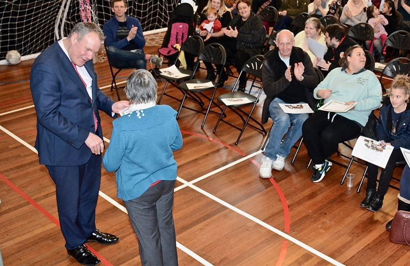 Conor pictured presenting an award for a volunteer. 