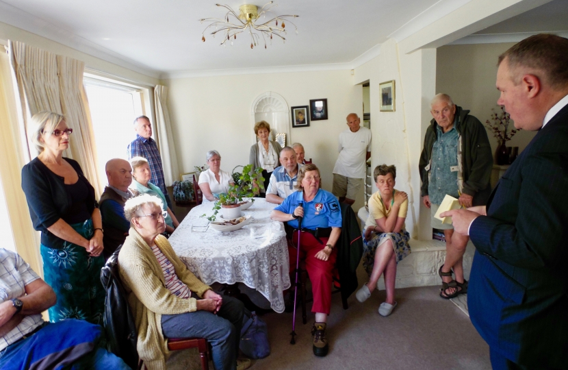 Conor addressing a house meeting in Alderney.