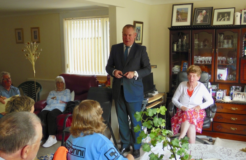 Conor addressing a house meeting in Alderney.