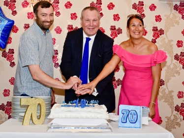 Conor cutting the cake with Sarah England and Matthew Moore.